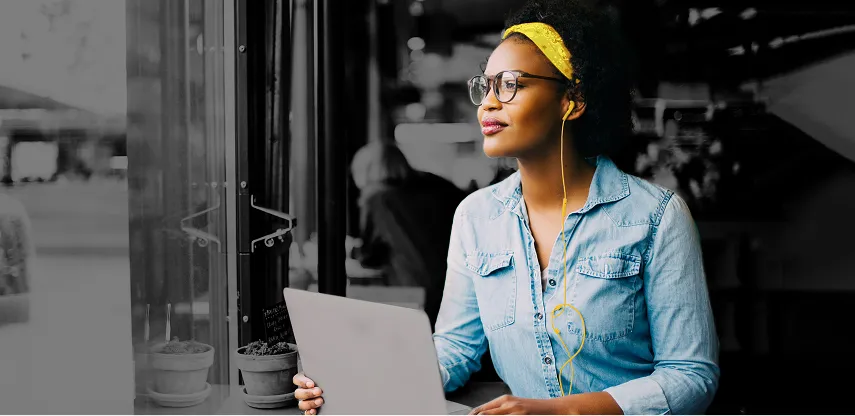 Woman wearing a yellow headband, glasses, with earbuds working