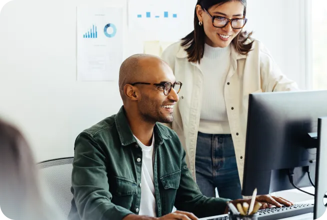 Co-workers using a computer together in a creative office