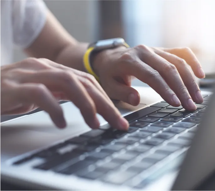 Close up of hands typing on a laptop computer