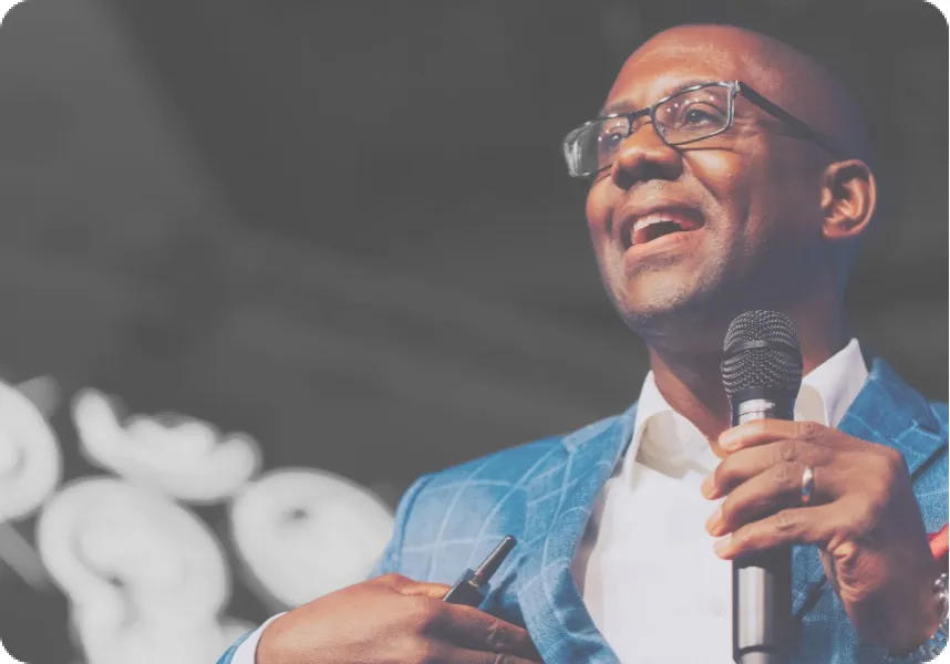 Ramon Ray speaking into a microphone while giving a presentation at a conference